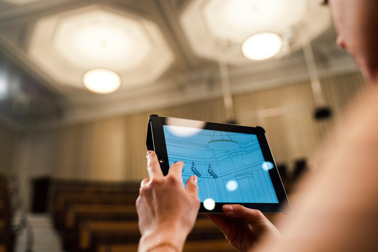 Mastering the First Impression: Your intriguing post title goes here Woman engineer utilizing a digital tablet to design a ceiling in a modern auditorium setting.